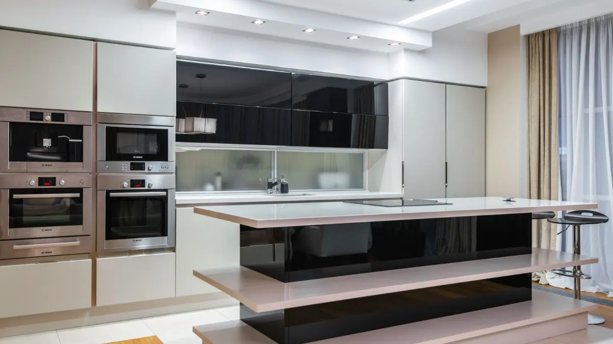Cocina con isla de superficie lisa y hornos en columna