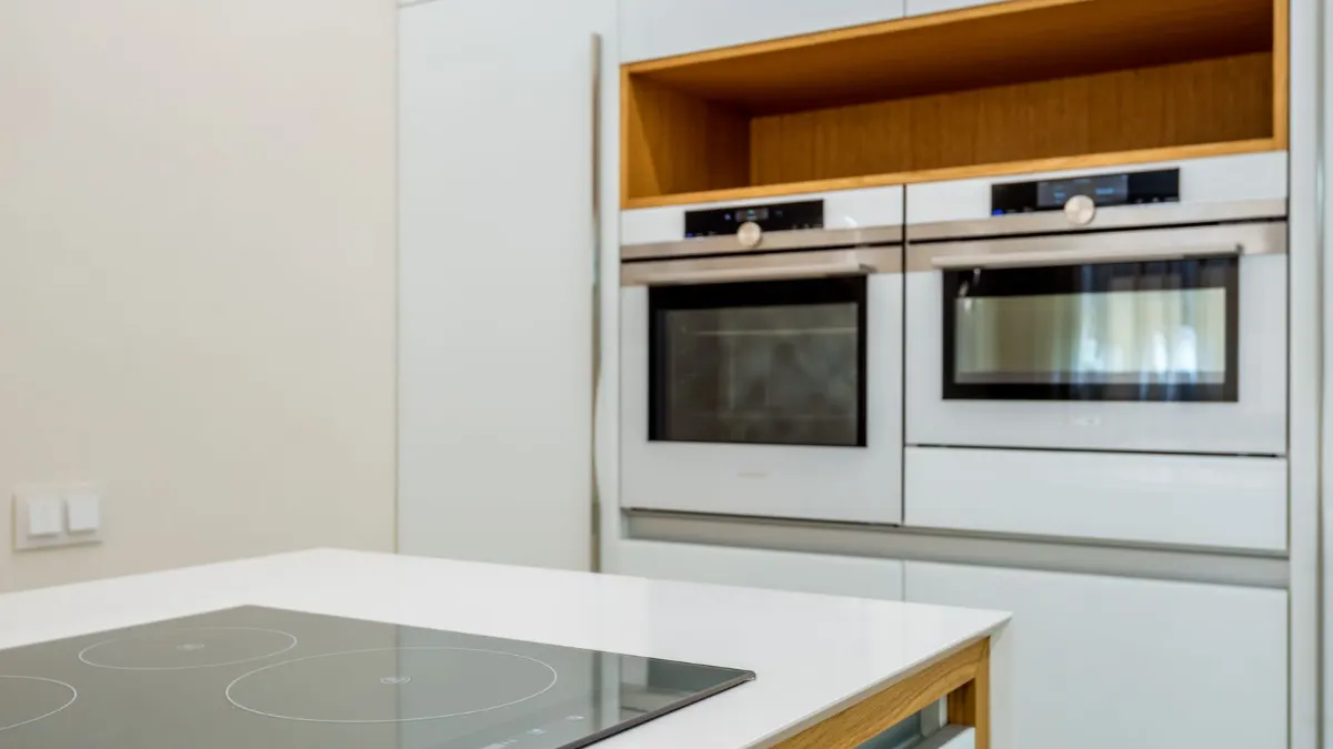 Cocina blanca con hornos en columna y placa de inducción en la encimera