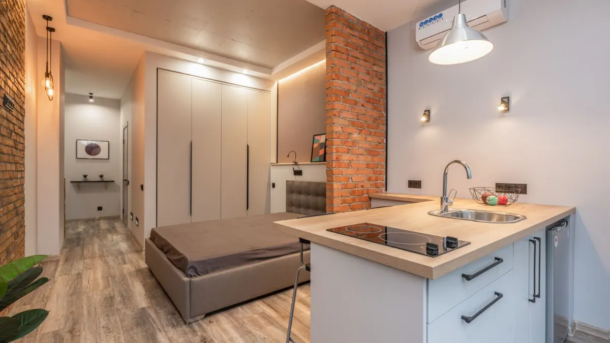 Estudio con cocina compacta integrada en el salón