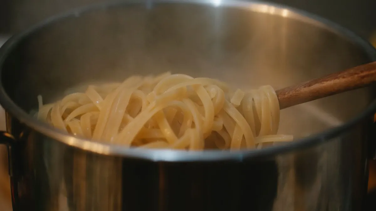 Espaguetis cociéndose en una olla de acero