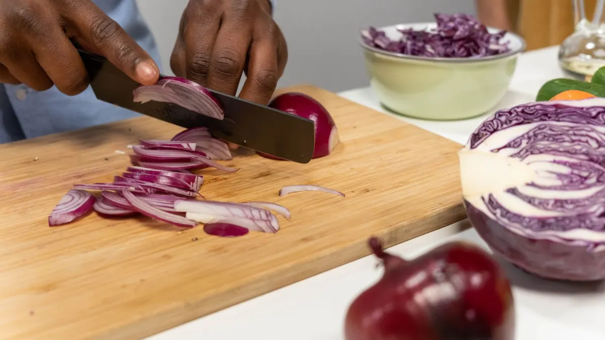 Cortando cebolla morada y lombarda en una tabla