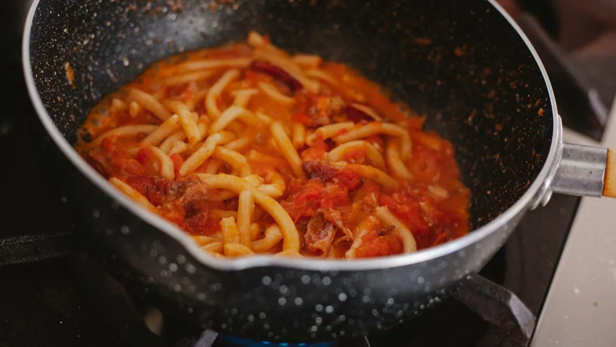 Pasta con tomate en una sartén